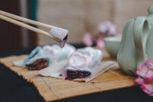 chocolate mochi held with chopsticks Japanese dessert